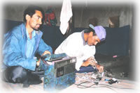 men repairing radio equipment in Shimshal, Pakistan